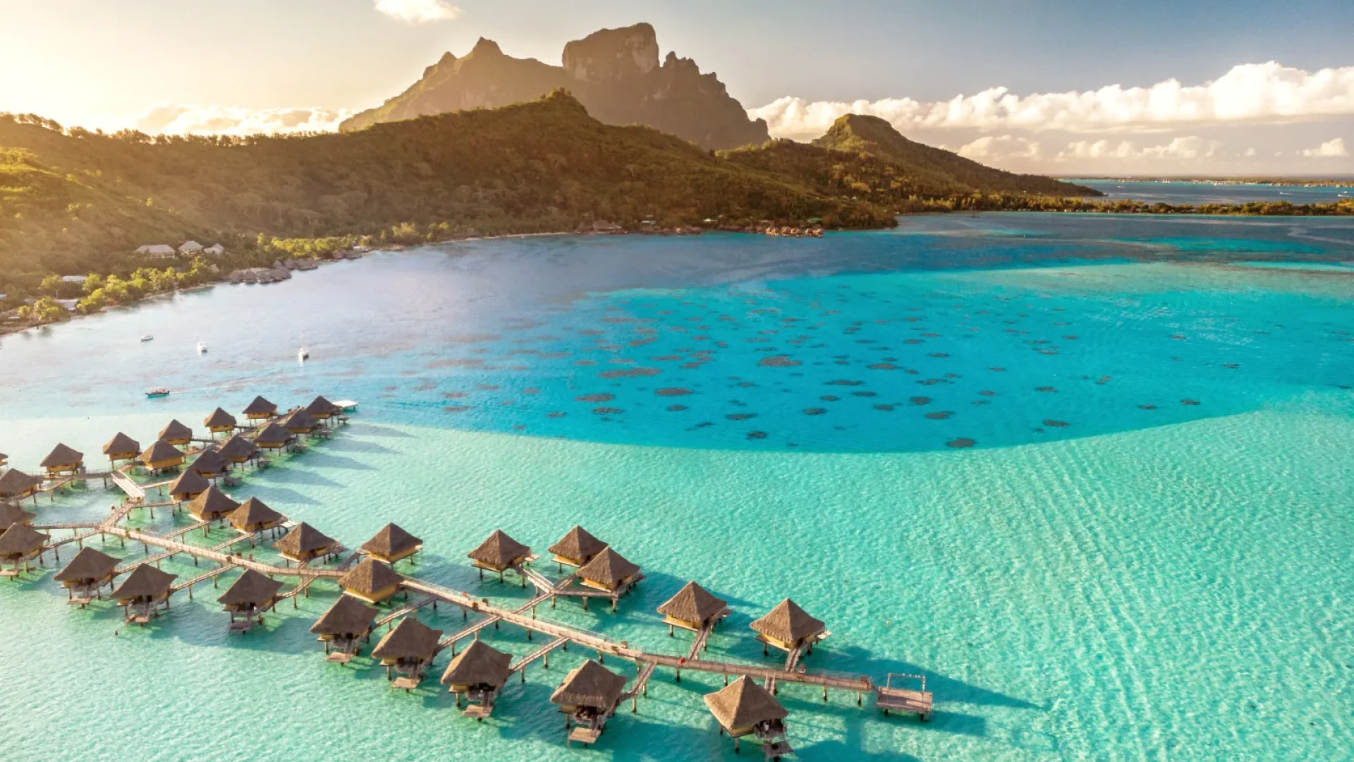Vista de Matira Beach em Bora Bora, com uma longa faixa de areia branca e águas cristalinas, ideal para relaxar e desfrutar de tranquilidade e privacidade.