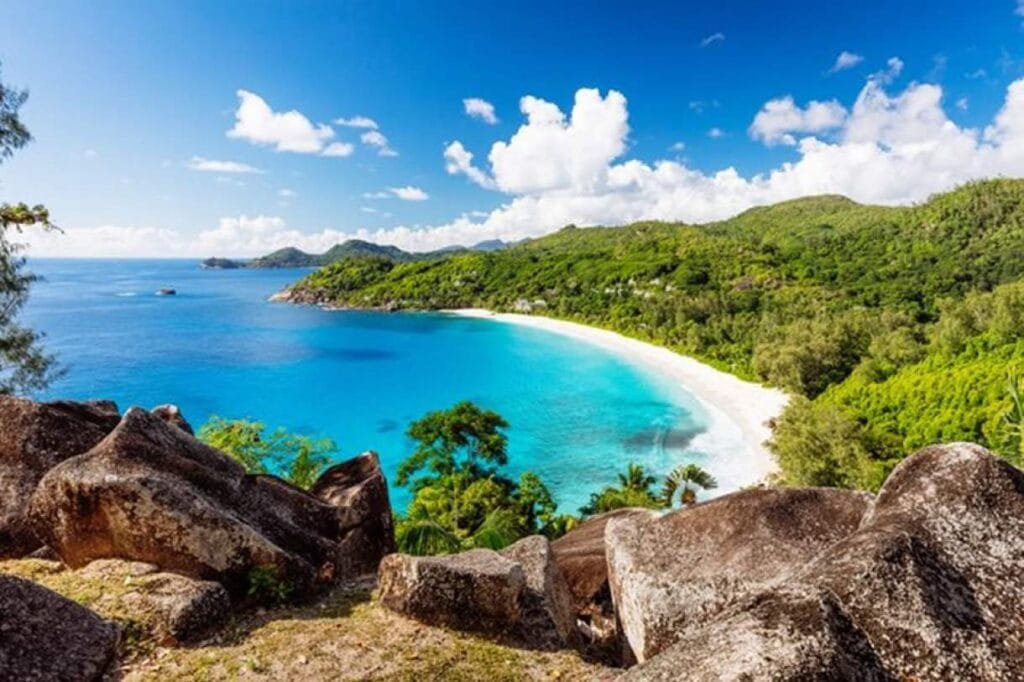 Vista panorâmica de Anse Source d’Argent em Seychelles com águas azul-turquesa, areias cor-de-rosa e formações de granito únicas.